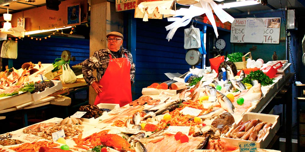 Рыбная лавка со свежими рыбой и морепродуктами и колоритным хозяином магазина